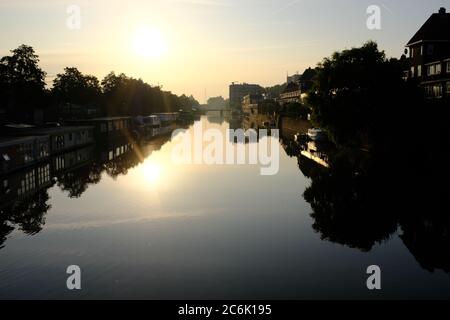 Silueta de edificios modernos en el río IJ en el verano justo antes de la puesta de sol en Amsterdam, Holanda