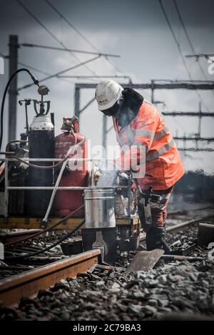 Equipo de mantenimiento que realiza soldadura térmica en vías férreas en el Reino Unido. Foto de stock