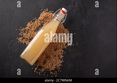 Arriba ver casero tradicional ruso claro centeno kvass en botella sobre fondo de madera oscura. Una bebida refrescante y saludable para el verano