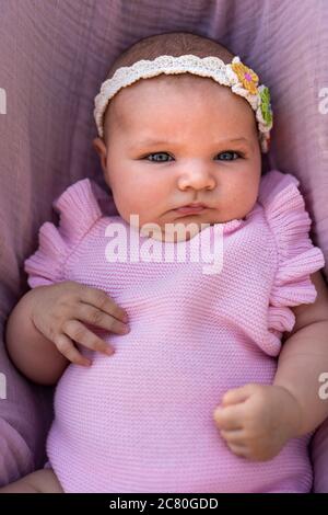 Bebé recién nacido niña con ropa de punto rosa y un floral