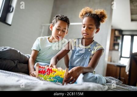 Niños afroamericanos felices aprenden a contar en casa con abacus Foto de stock