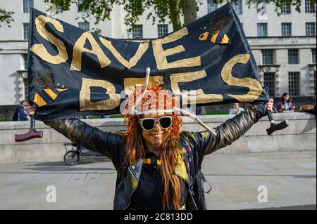 LONDRES - 18 DE OCTUBRE de 2019: Extinction Rebellion Protester tiene una bandera de Save Bees en una marcha de protesta por la Rebelión de extinción