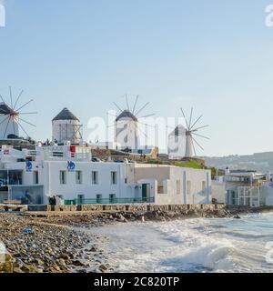 Una serie de molinos en la colina cerca del mar en la isla de Mykonos en Grecia, la atracción principal de la isla Foto de stock