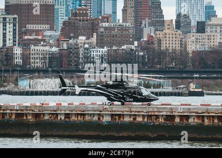 Un helicóptero de Marca Uber en el helipuerto del centro de Manhattan, Nueva York. Disponible para reservar en los aeropuertos JFK/EWR en la aplicación móvil Uber Foto de stock