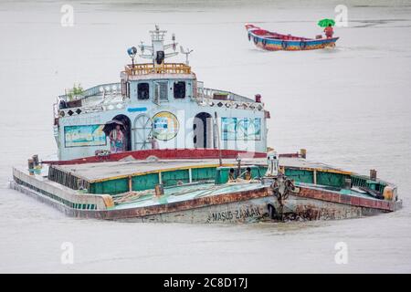 Una barcaza de arena muy cargada en su camino para descargar arena a las fábricas de cemento cerca del puente Kanchon en las afueras de Dhaka en Bangladesh. Los ríos son los principales minerales de transporte en el país del delta. Foto de stock
