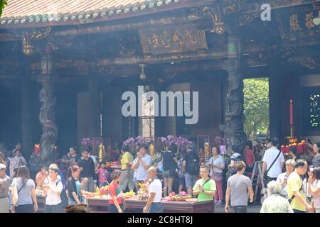 Taipei Taiwán - Templo Lungshan escena ocupada de gente budista orando Foto de stock