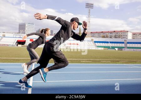 Joven pareja de correr. Vista lateral completa shot.willpower, fuerza, concepto de determinación. Espacio de copia. Concepto del concurso