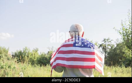 El patriótico anciano celebra el día de la independencia de los estados unidos el 4 de julio con una bandera nacional en sus manos. Día de la Constitución y la Ciudadanía. Gran Nacional Foto de stock