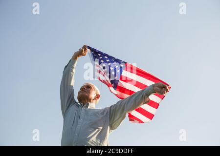 El patriótico anciano celebra el día de la independencia de los estados unidos el 4 de julio con una bandera nacional en sus manos. Día de la Constitución y la Ciudadanía. Gran Nacional Foto de stock