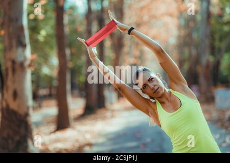 Mujer haciendo ejercicio con banda de resistencia al aire libre. Foto de stock