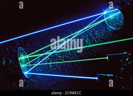 Punteros láser verde y azul con rayos visibles que se reflejan en los espejos. láseres de 532 nm (verde) y 445 nm (azul). Ciencia, física, reflexión, luz. Foto de stock