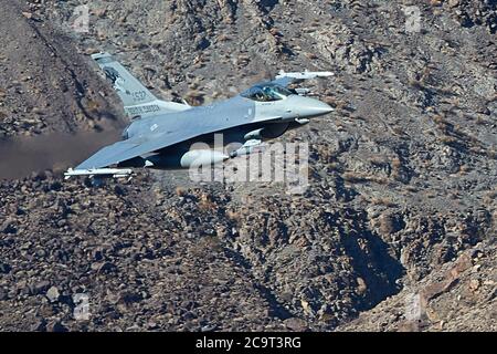 South Dakota Air National Guard F-16C, volando a alta velocidad y a baja altitud a través de Rainbow Canyon, California, EE.UU. Foto de stock