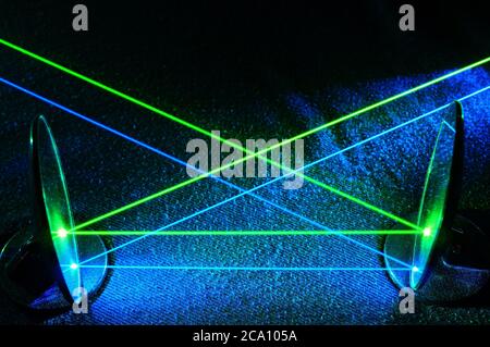 Rayos láser verde y azul que se reflejan en los espejos en líneas paralelas. Láser, ciencia, luz, haz visible, colimado, enfocado, colorido Foto de stock