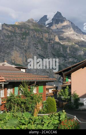 Casas en Murren con el pico Jungfrau en el fondo, Berner Oberland, Suiza Foto de stock