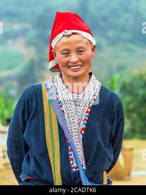 TA PHIN, LAO CAI, VIETNAM - 21 DE NOVIEMBRE de 2014: Mujer del grupo minoritario de Dao rojo que llevaba un casco tradicional cerca de la aldea de Ban Ho, distrito de Sapa, Lao Cai,