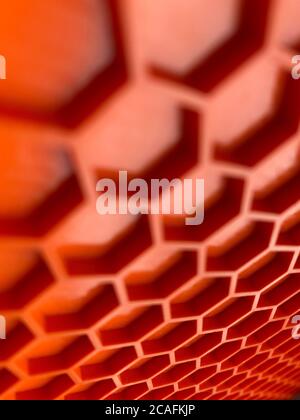 textura hecha de plástico naranja en forma de panales de miel de primer plano, fondo abstracto