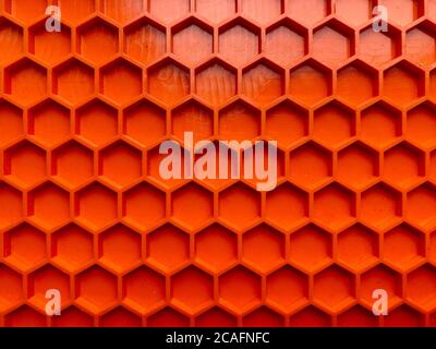 textura hecha de plástico naranja en forma de panales de miel de primer plano, fondo abstracto