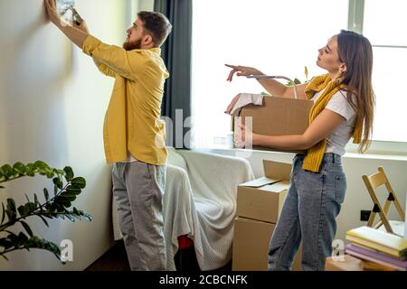 una joven pareja de casados caucásicos se trasladó a una nueva casa, desembalan las cajas en casa juntas Foto de stock