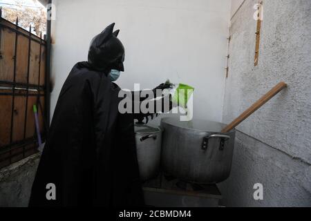 Un comerciante chileno y llamado 'Batman solidario' (Solidarity Batman)  cocina en su casa, durante el brote global de la enfermedad coronavirus  (COVID-19) en Santiago, Chile, 13 de agosto de 2020. El hombre,