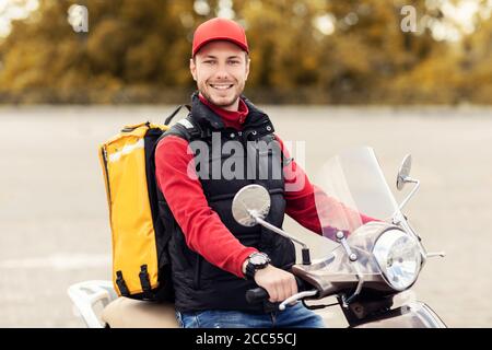 Feliz entrega Hombre con Mochila Amarilla Moto Scooter al aire libre  Fotografía de stock - Alamy