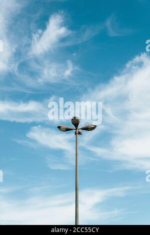 Disparo vertical de una farola con cuatro bulbos redondos contra un cielo nublado en Lisboa, Portugal Foto de stock