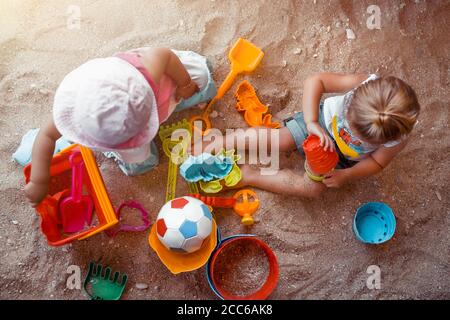 Dos niños pequeños felices jugando con diferentes Juguetes de Arena de colores. Con vacaciones divertidas y divertidas en el Beach Resort. Juegos de Verano activos. Sandbox