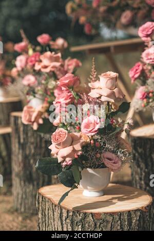 Arreglo de flores rosas en los troncos para una boda. Orientación vertical. Foto de stock
