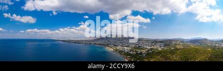 Atenas Grecia riviera panorama. Vista aérea de la costa de Voula y Glyfada, zona residencial de alta clase. Cielo azul nublado sobre agua de mar, sol Foto de stock