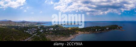 Atenas Grecia riviera panorama. Vista aérea de la costa de Vouliagmeni y Kavouri, distrito residencial de alta clase. Cielo azul nublado sobre el agua de mar Foto de stock