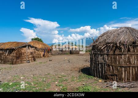 Pueblo tradicional Maasai con cabañas de arcilla redonda en la zona de Engare Sero cerca del Lago Natron y el volcán Ol Doinyo Lengai en Tanzania, África Foto de stock
