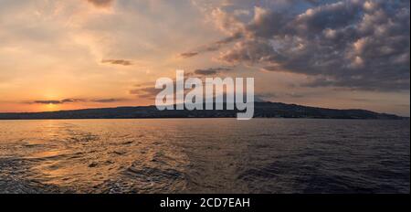 Una impresionante vista panorámica del volcán activo Etna y Catania al atardecer, vista desde el mar, Sicilia