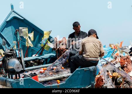 Marocco, Oued Ed-Dahab, Dakhla, Lassarga, pescadores preparando sus redes de pesca en la playa Foto de stock