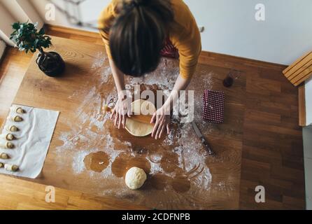 Vista en ángulo alto de la mujer amasando masa de pan en la cocina tabla
