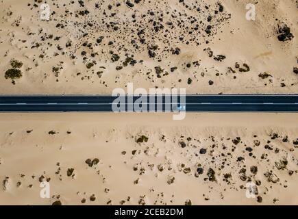 La conducción del automóvil en la carretera en el pintoresco desierto