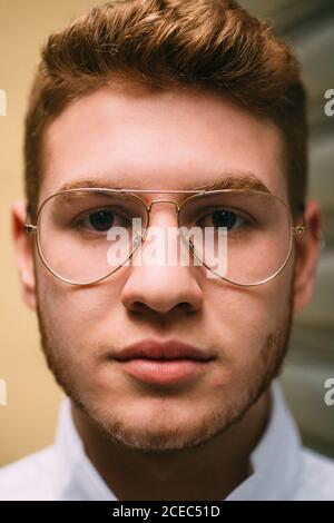 Primer plano del alegre hombre pelirrojo brillante con gafas elegantes  mirando la cámara con emoción Fotografía de stock - Alamy