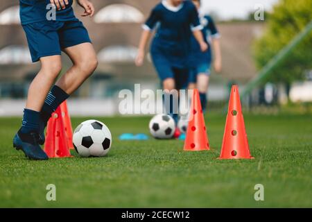 Niño en equipo de fútbol infantil en entrenamiento. Niños practicando al  aire libre con pelotas de fútbol. Sesión de entrenamiento de fútbol para  niños en el campo de fútbol. Joven b Fotografía