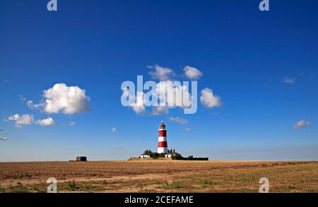 Una vista del faro de funcionamiento independiente contra un cielo azul con nubes blancas en la costa de North Norfolk en Happisburgh, Norfolk, Inglaterra, Reino Unido.