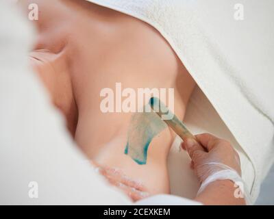 CloseUp Hands en guantes aplica cera verde caliente en las nalgas de la  mujer usando espátula. Procedimiento de depilación, depilación con cera  caliente en salón de belleza Fotografía de stock - Alamy