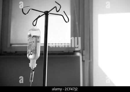 Foto en blanco y negro de una bolsa de goteo con electrolitos de pie en el hospital Foto de stock