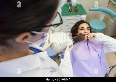 dentista y su asistente tomando una radiografía del paciente dentición Foto de stock