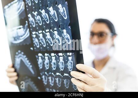 dentista femenino que revisa la radiografía del paciente Foto de stock