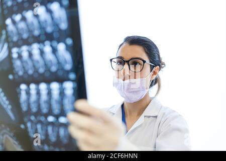 dentista femenino que revisa la radiografía del paciente Foto de stock