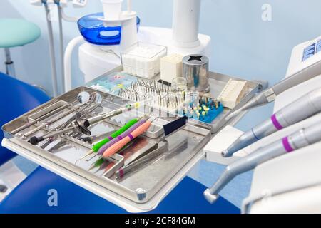 De arriba herramientas dentales de color de alta calidad y jeringa con medicina en bandeja de acero Foto de stock