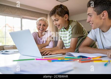 Madre ayudando a sus hijos a hacer la tarea en casa