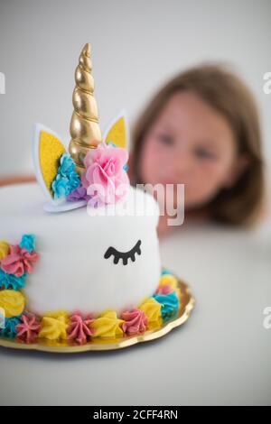 Pastel de unicornio brillante para una chica feliz en la mesa Fotografía de  stock - Alamy