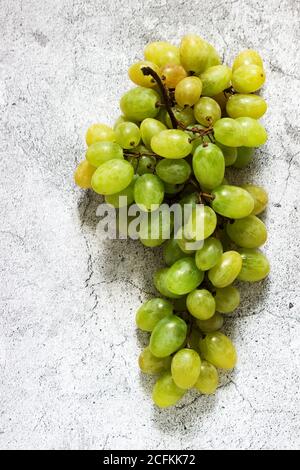Racimos de uvas de color ámbar sobre un fondo de hormigón gris. Foto de stock