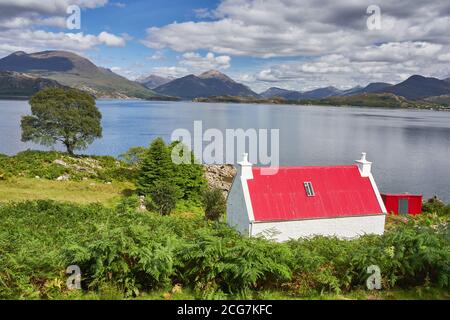 Casa con techo rojo cerca de Ardheslaig en las orillas del lago Shieldaig Península de la ERADA Wester Ross Escocia Foto de stock