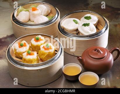Comida asiática variada dim sum en vaporera de bambú Foto de stock