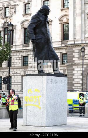 La estatua de Winston Churchill, después de que fue vandalizada con las palabras "ES UN RACISTA" rociado en pintura amarilla en el zócalo, en la Plaza del Parlamento, Londres, en el último día de manifestaciones. Foto de stock