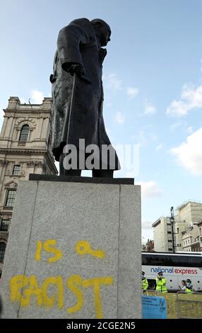 La estatua de Winston Churchill, después de que fue vandalizada con las palabras "ES UN RACISTA" rociado en pintura amarilla en el zócalo, en la Plaza del Parlamento, Londres, en el último día de manifestaciones. Foto de stock